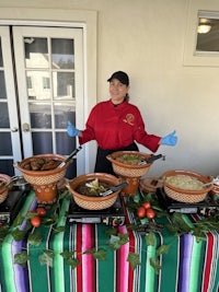 a woman standing in front of a table full of mexican food