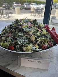 a salad is sitting on a table next to a sign